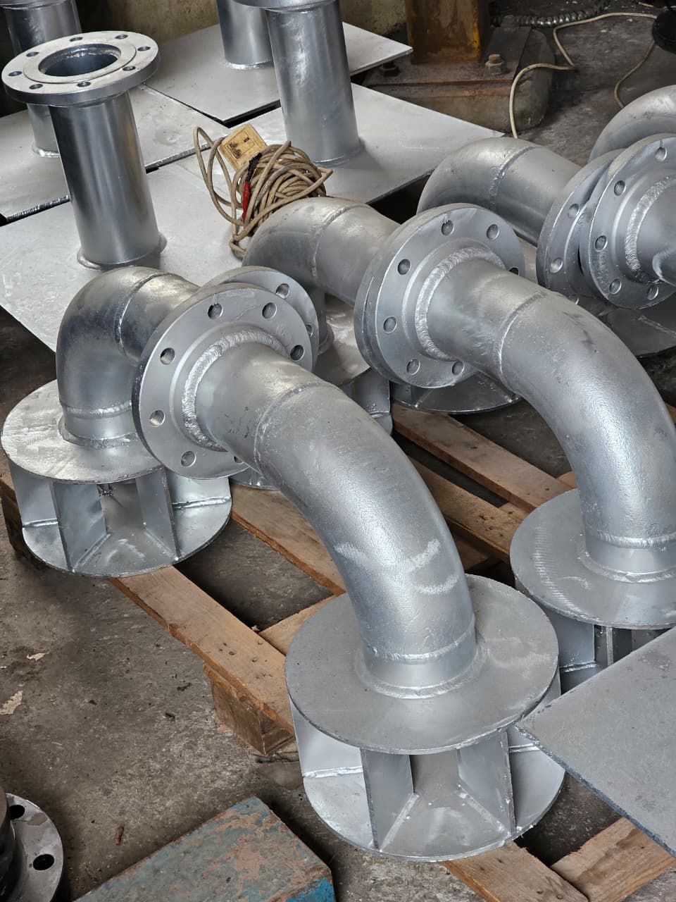 Fabricated galvanized flanged pipe and elbow assemblies prepared in the workshop