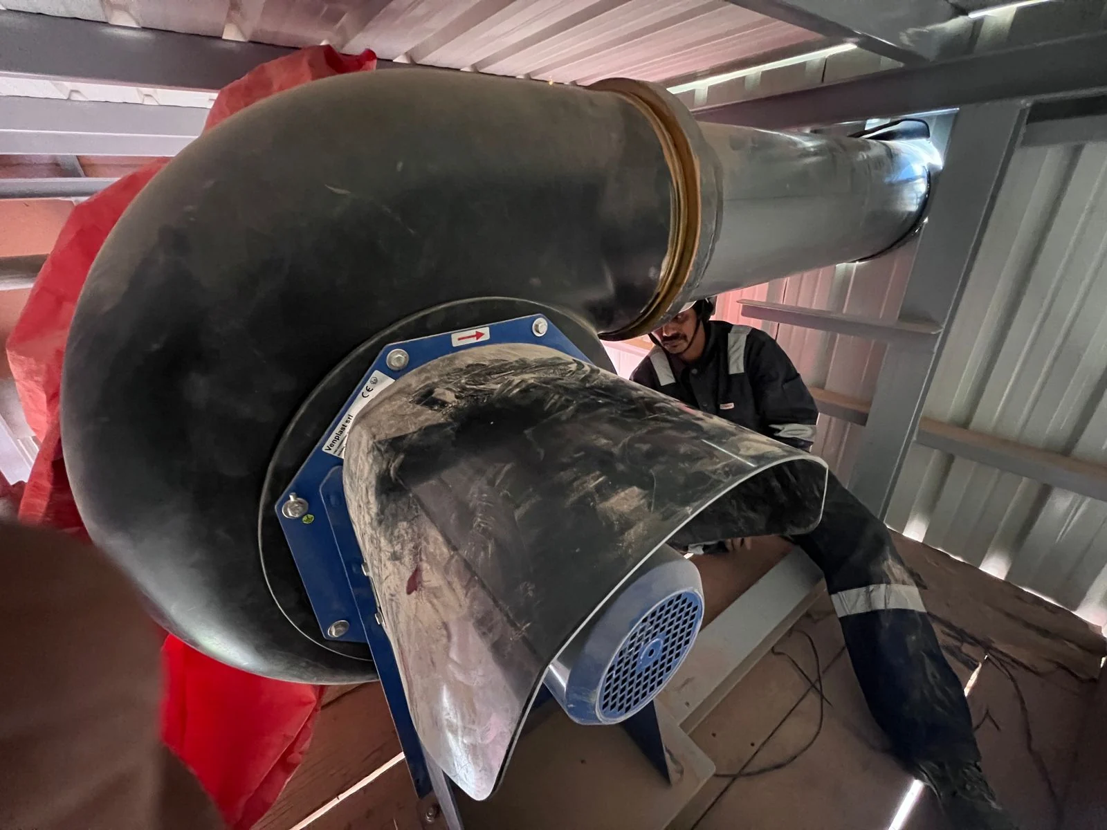 Close view of an industrial ventilation fan and duct assembly during installation
